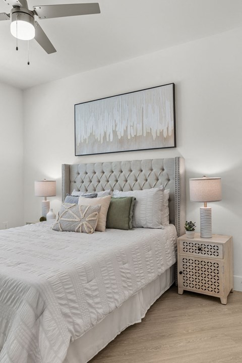 a bedroom with a bed and a painting on the wall