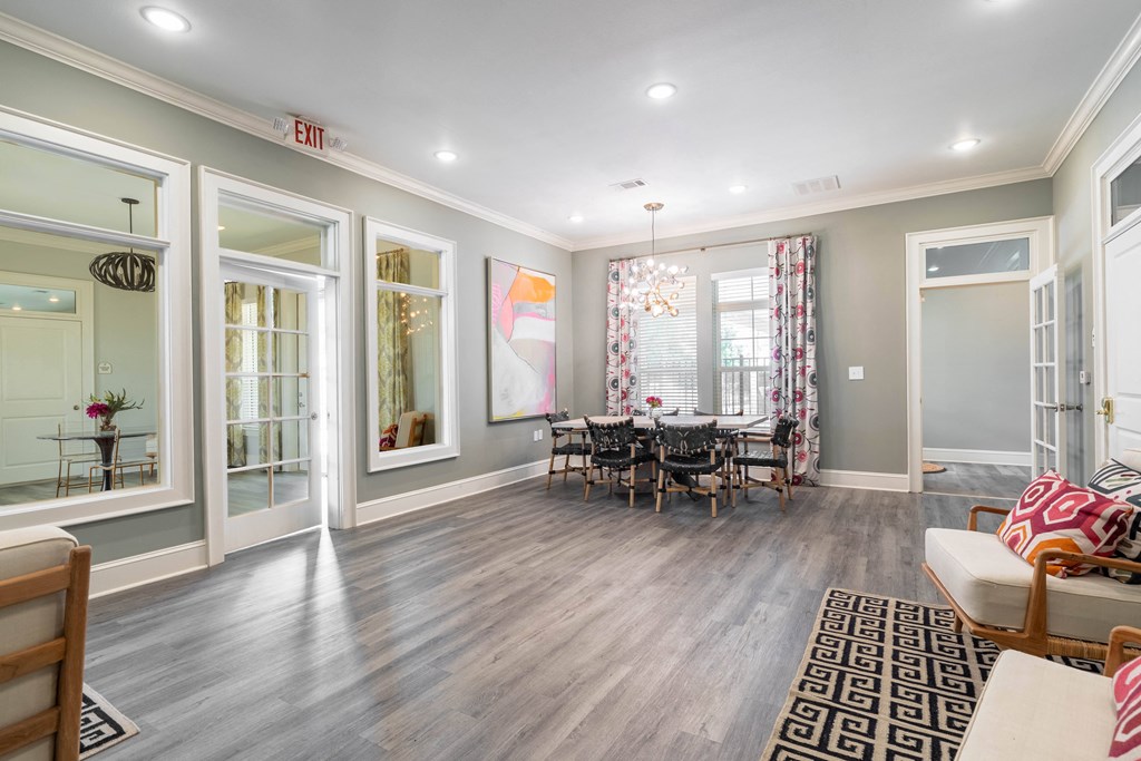 a living room with a dining room table and windows