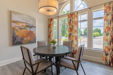 a dining room with a large window and a table with chairs