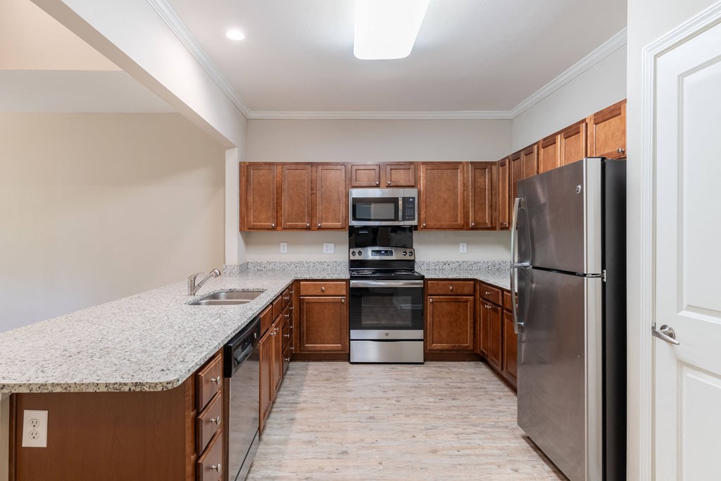a kitchen with wood cabinets and granite counter tops and stainless steel appliances
