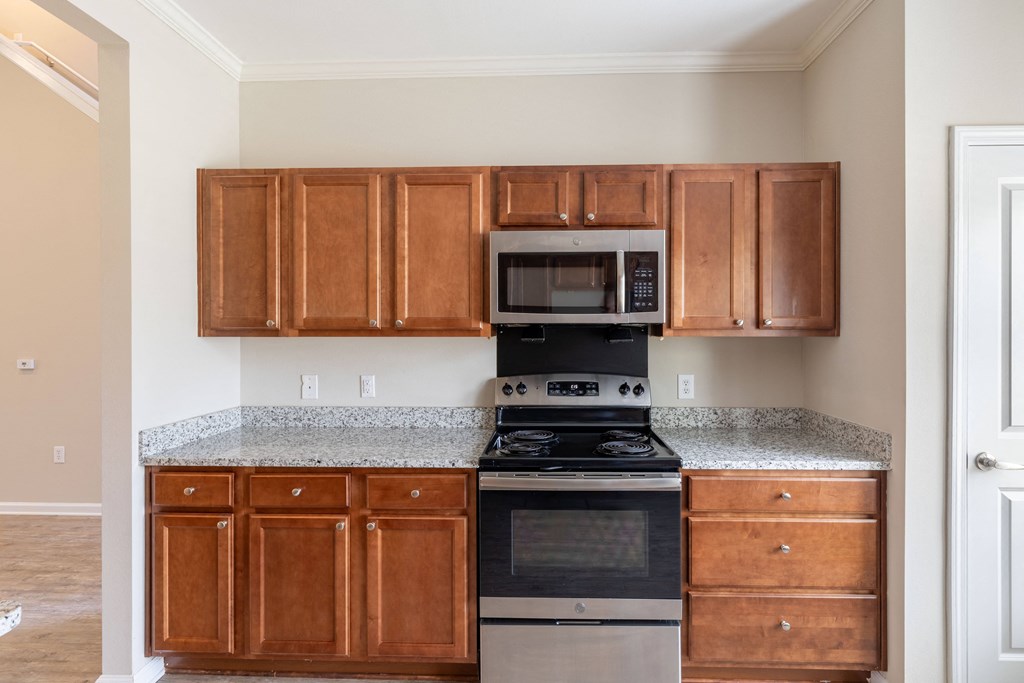 a kitchen with wood cabinets and black appliances and granite counter tops