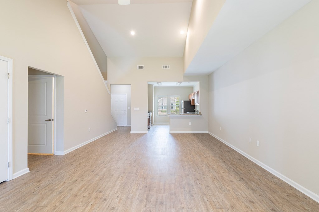 an empty living room with a hard wood floor and white walls
