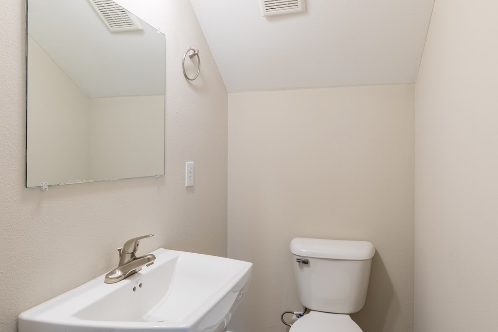 a bathroom with a toilet and a sink and a mirror
