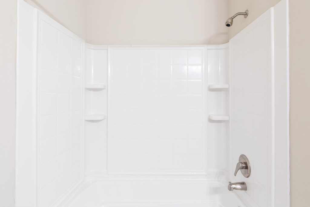 a white bathroom with a shower and a sink