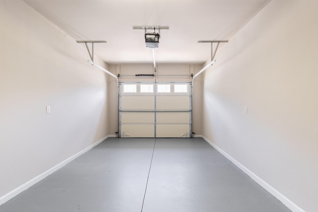 an empty room with white walls and a garage door