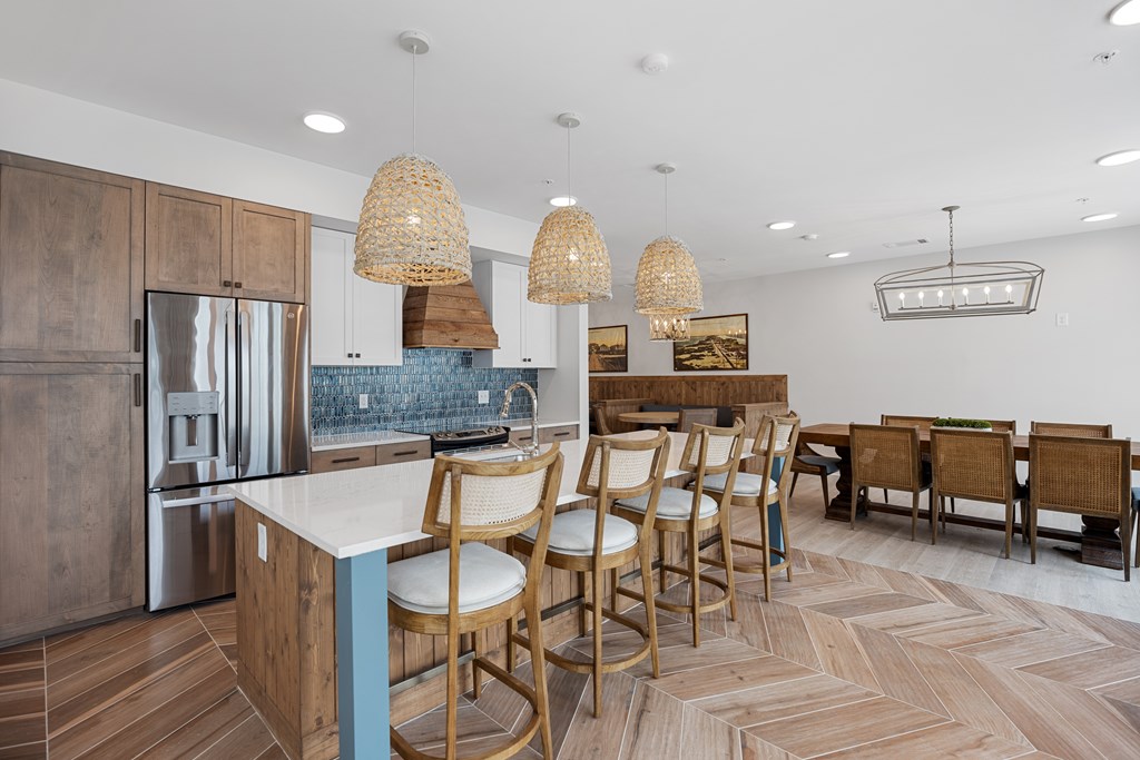 Clubhouse Kitchen with Wooden Chairs, White Counter and Bar Stools.