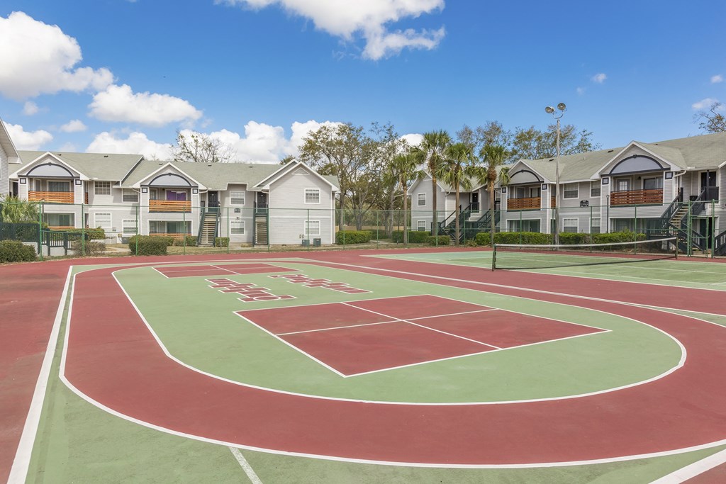 an outdoor basketball court with apartments in the background