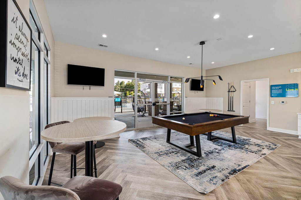a living room with a pool table and a tv