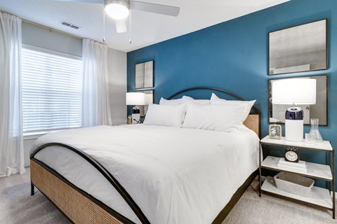 A bedroom with a large bed and a ceiling fan.