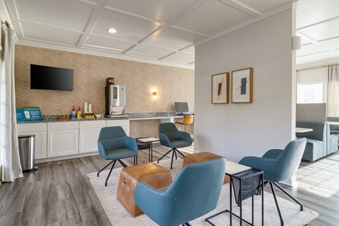 A modern kitchen with blue chairs and a wooden table.