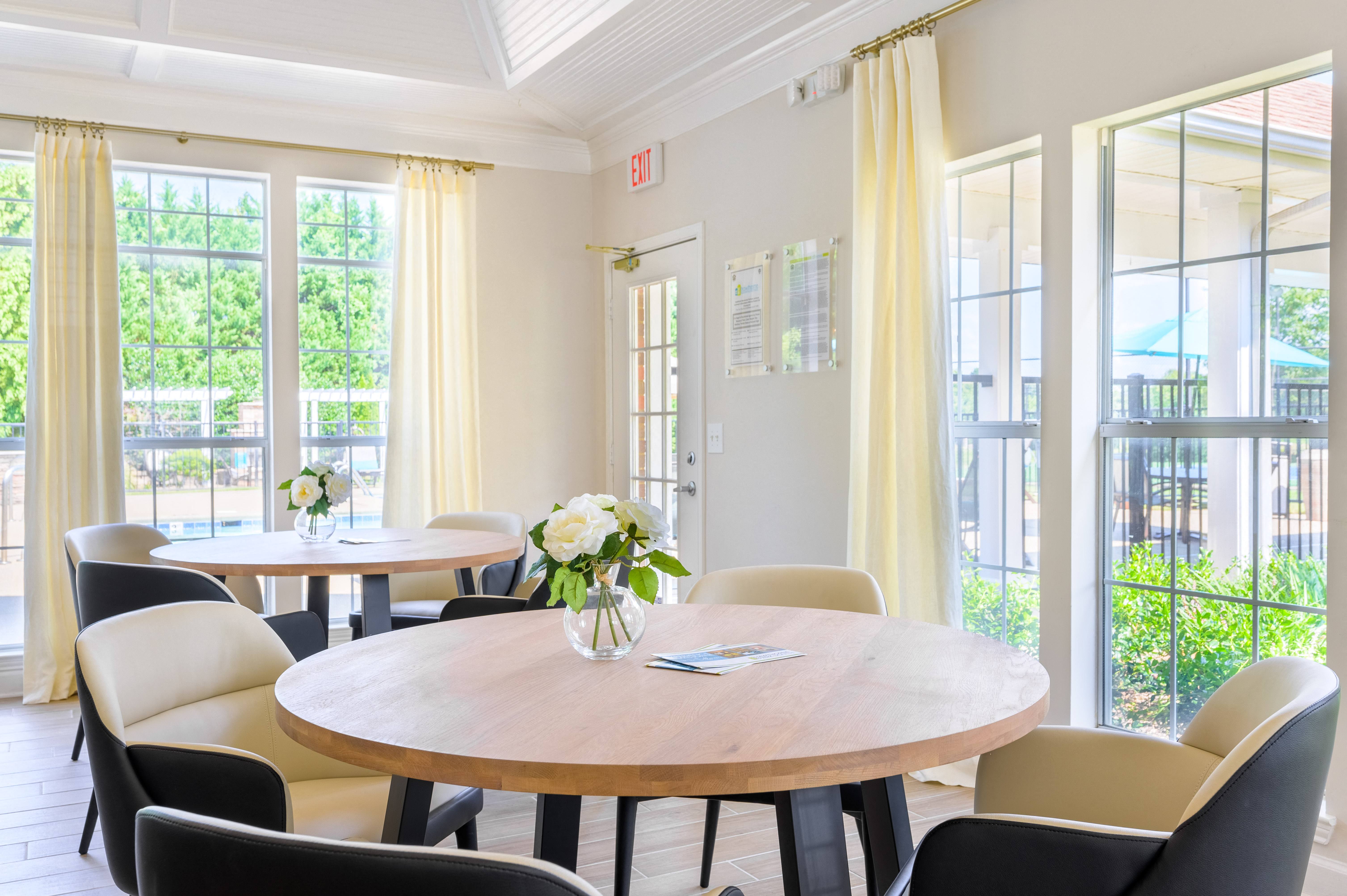 A dining room with a round table and chairs.