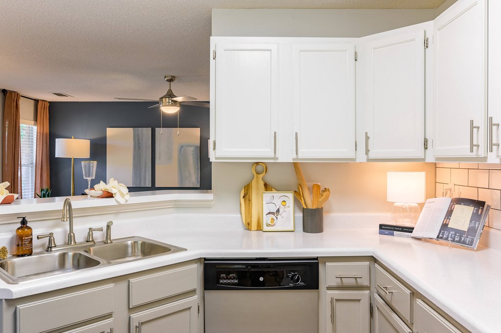 a kitchen with white cabinets and a sink and a dishwasher