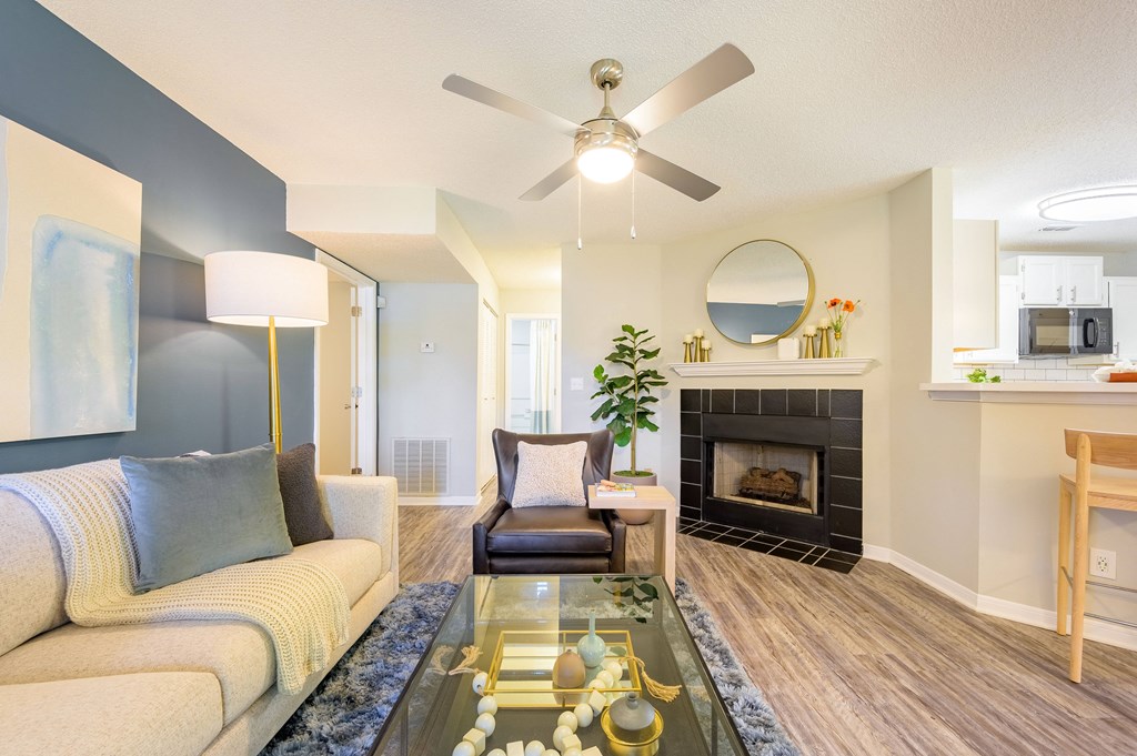 a living room with a fireplace and a ceiling fan