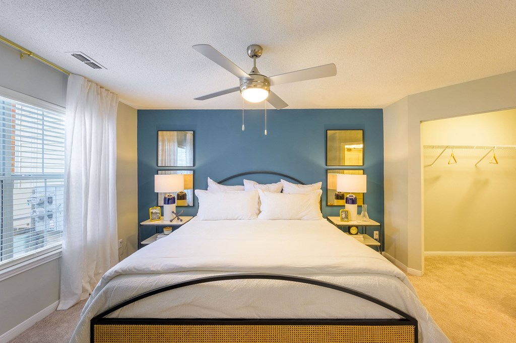 a bedroom with a large bed and a ceiling fan