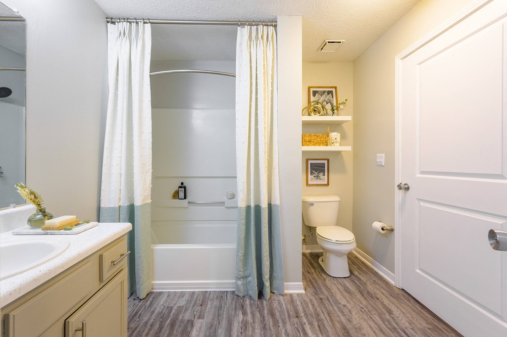 a bathroom with a shower and a toilet and a sink