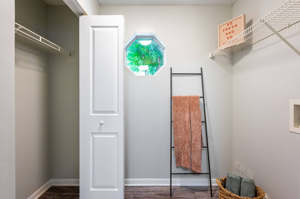a closet with a ladder and a window on the wall