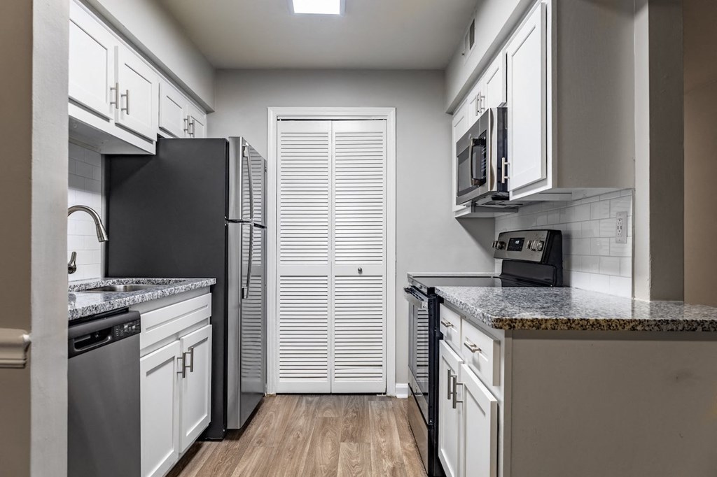 a kitchen with white cabinets and black appliances