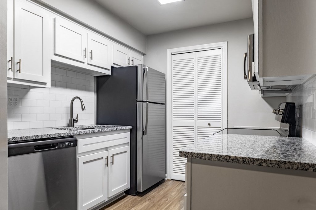 a kitchen with white cabinets and a black refrigerator