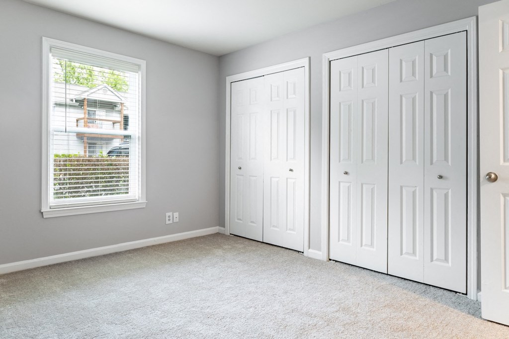 a bedroom with two closets and a window