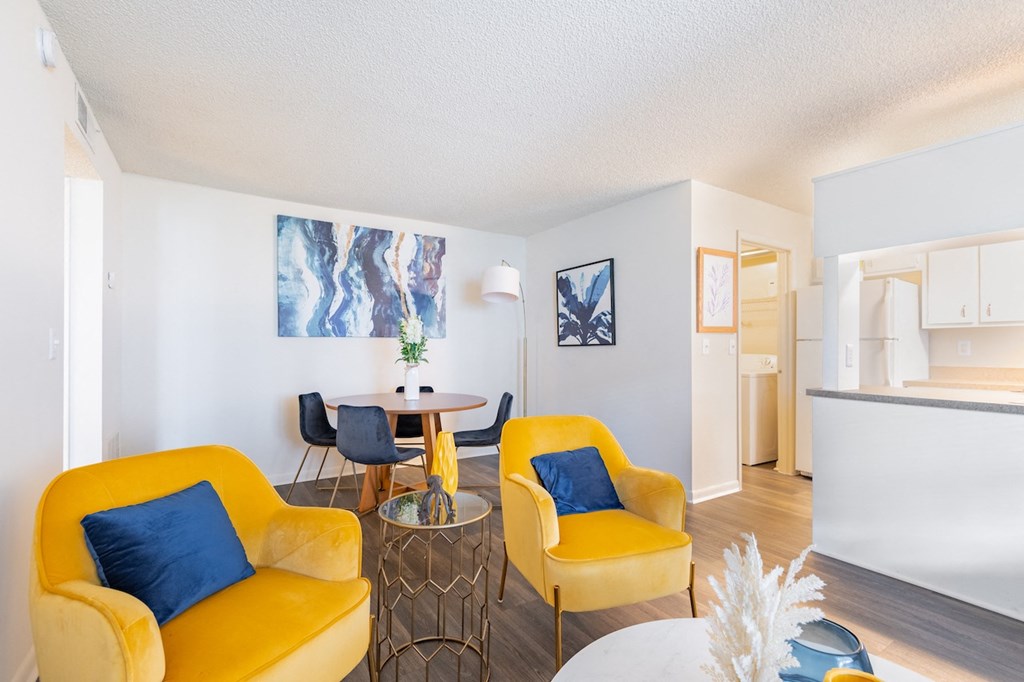 a living room with two yellow chairs and a table