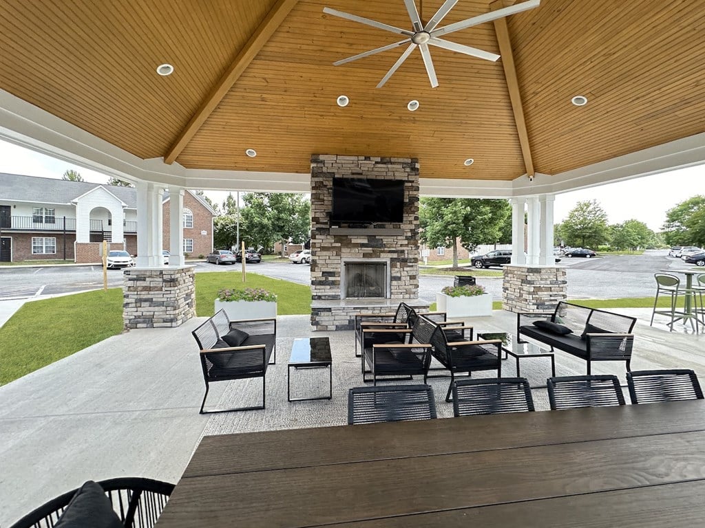 a covered patio with a fireplace and a table and chairs