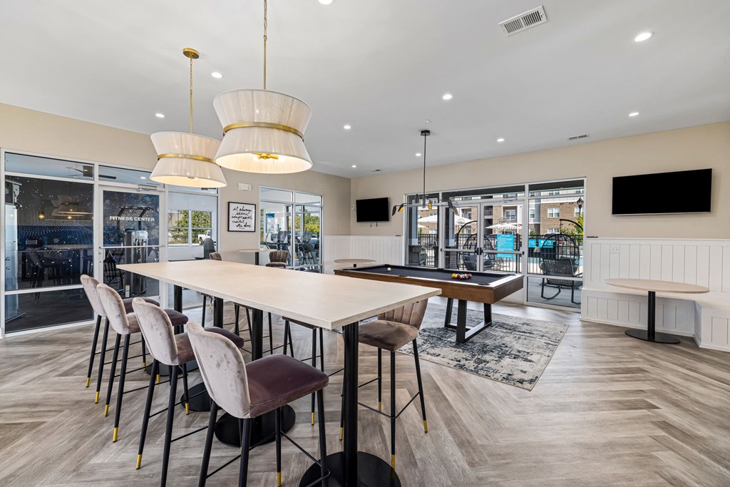 a communal dining room with tables and chairs and a pool table