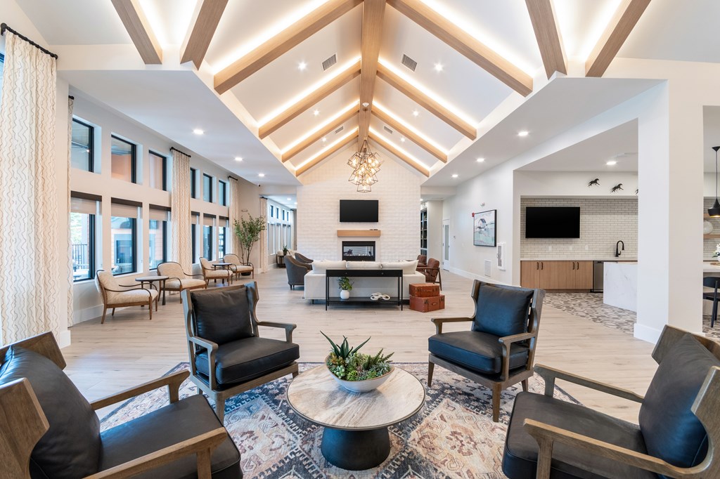 A spacious living room with a high ceiling and a central coffee table.