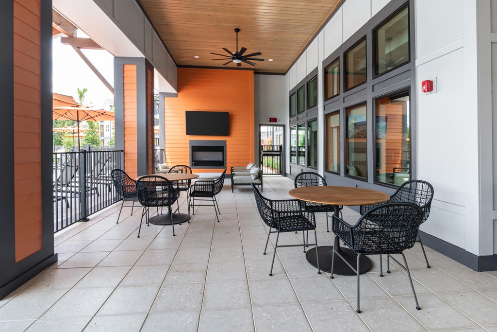 A patio with a table and chairs and a ceiling fan.