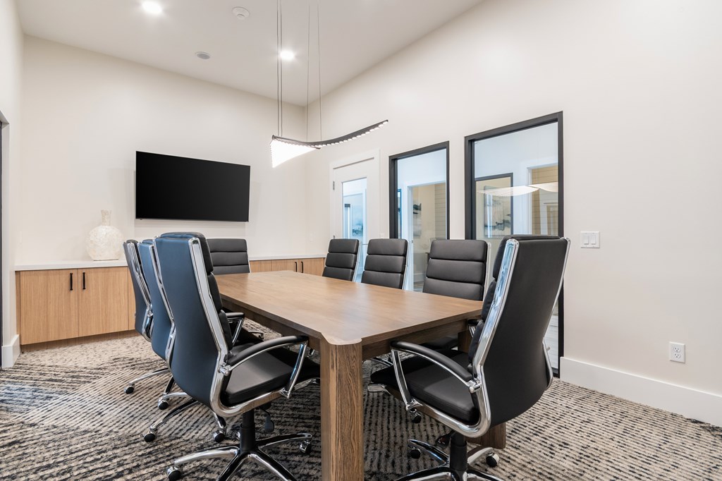 A conference room with a large table and chairs.