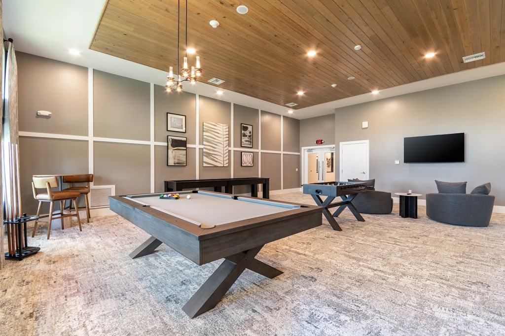 A room with a pool table and a television.