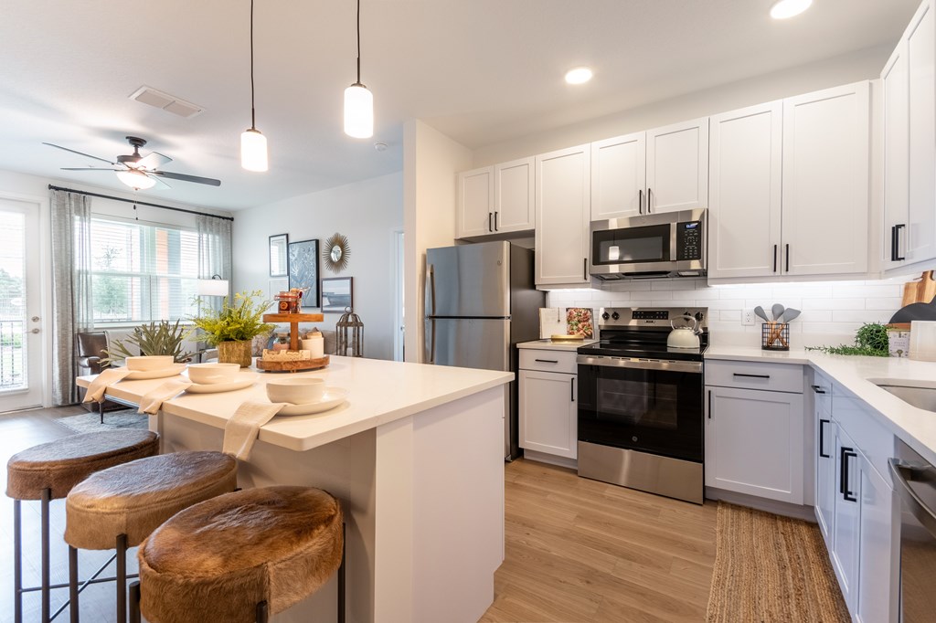 A modern kitchen with white cabinets and stainless steel appliances.