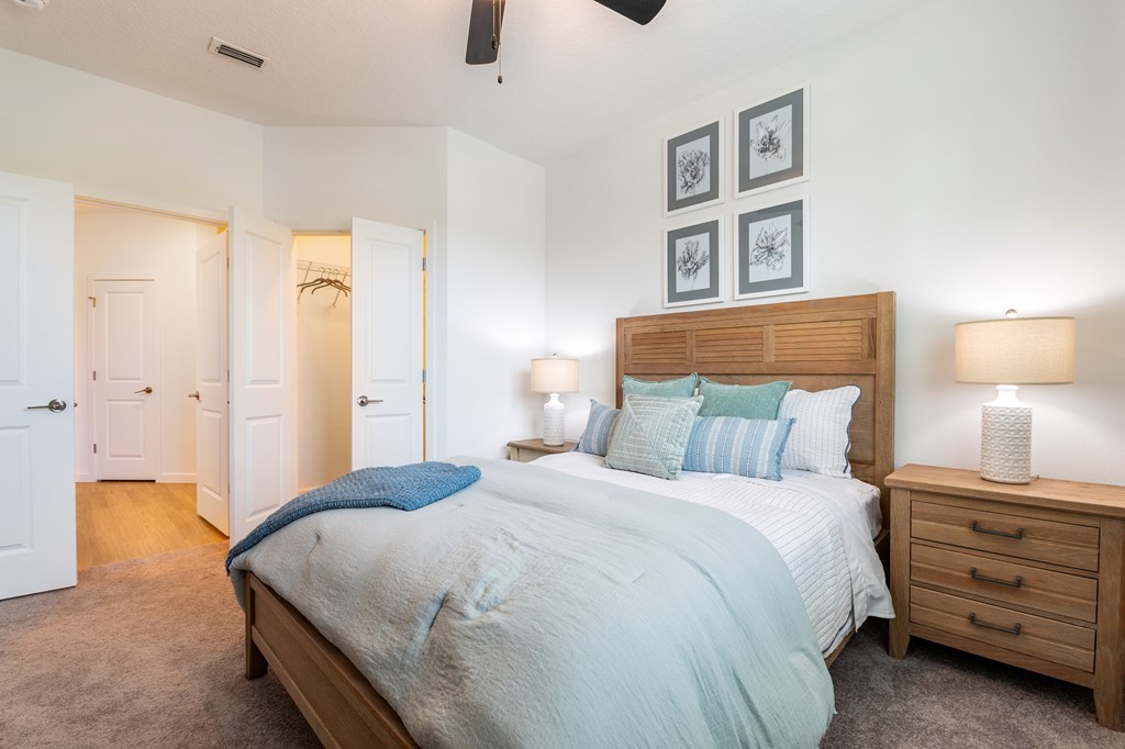 A bedroom with a bed, nightstand, and two lamps.