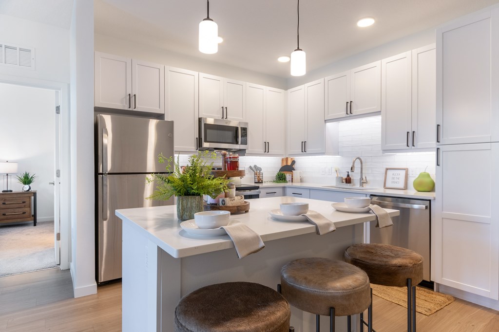 A modern kitchen with white cabinets and a central island.