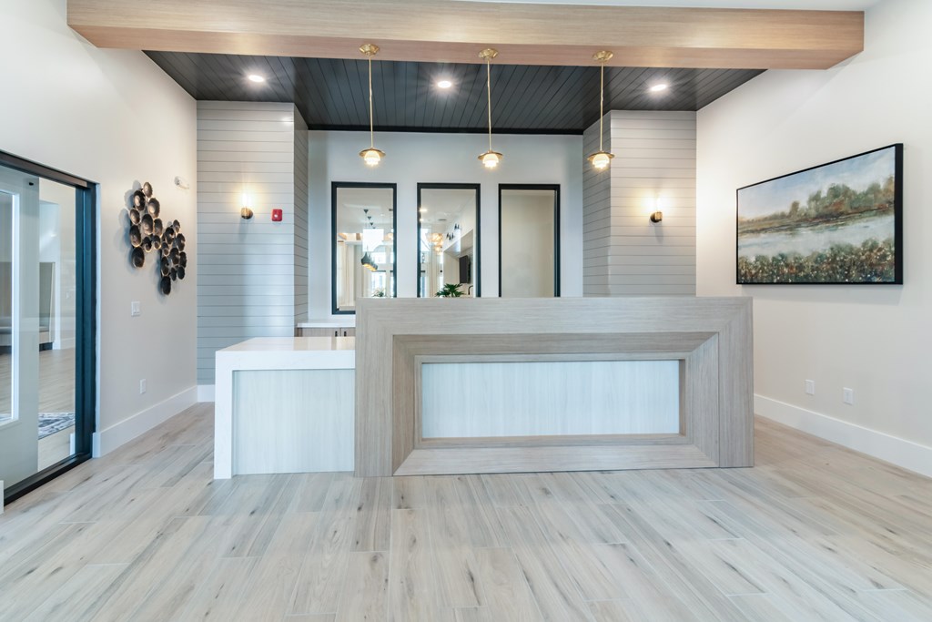 A reception area with a white reception desk and a framed painting on the wall.