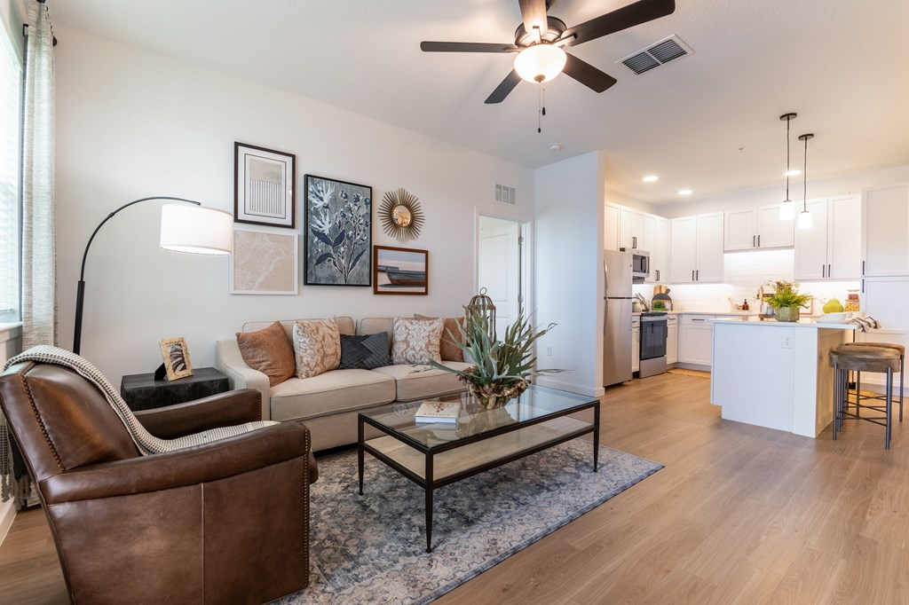 A living room with a brown leather chair and a glass coffee table. at SW 38th Avenue Apartments in Ocala, FL