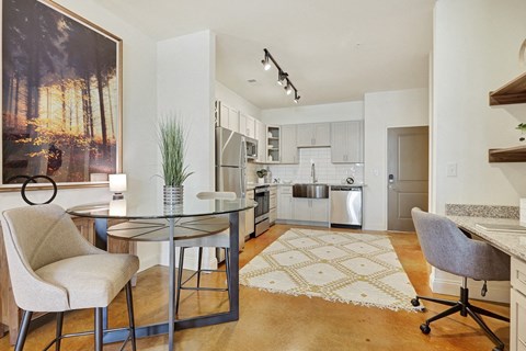 A modern kitchen with a glass table and chairs.
