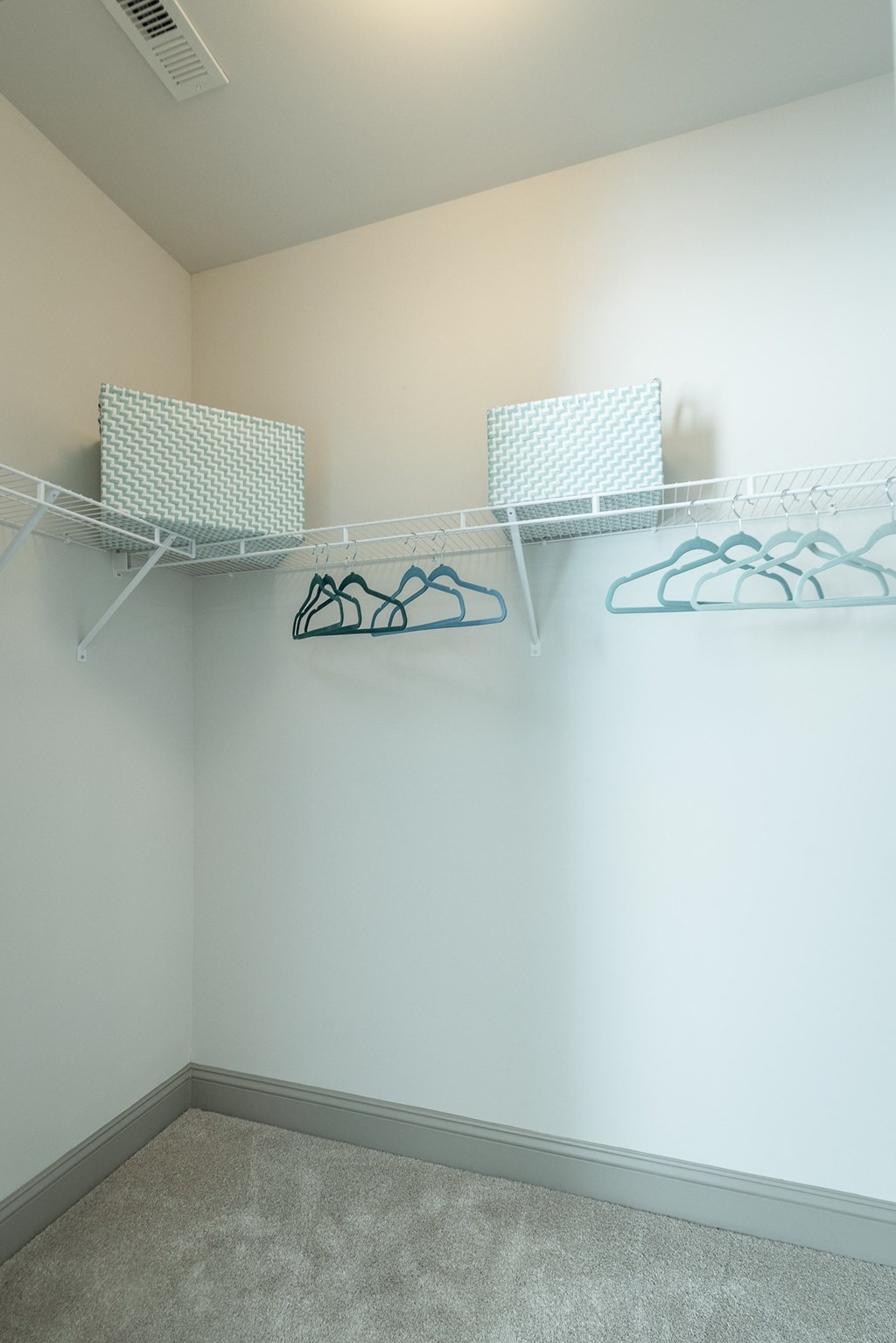an empty closet with two shelves and two baskets on the wall