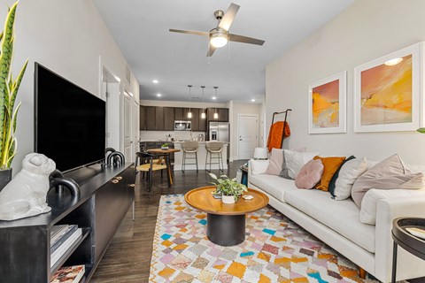 A living room with a white couch and a ceiling fan.