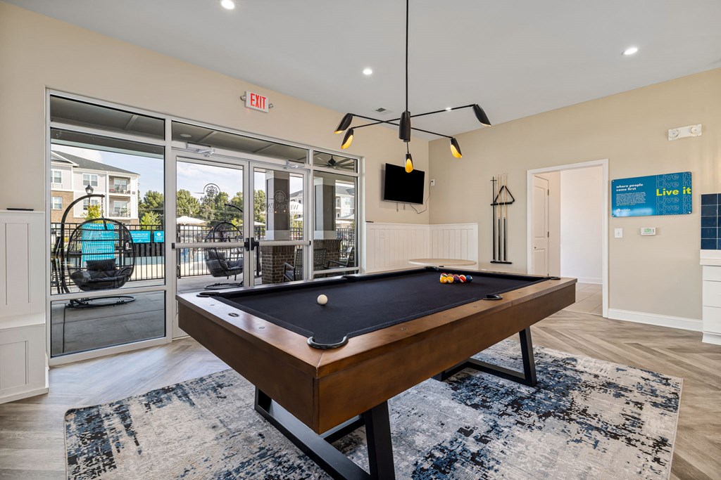 a pool table in a living room with a sliding glass door