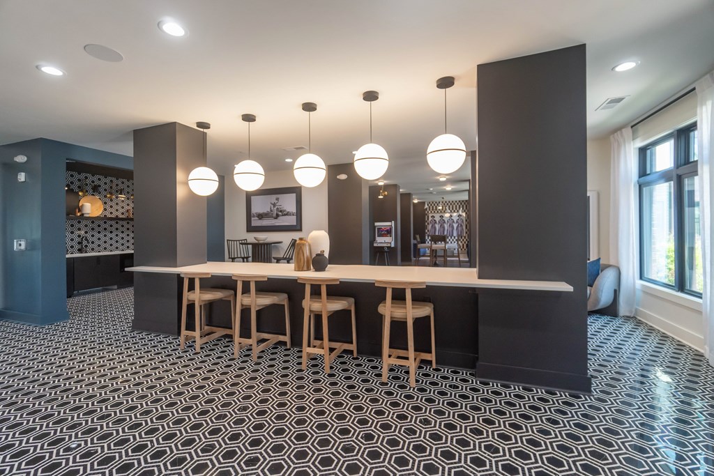A black and white tiled floor with a wooden table and chairs at Evolve Lake Norman apartments in Mooresville, NC