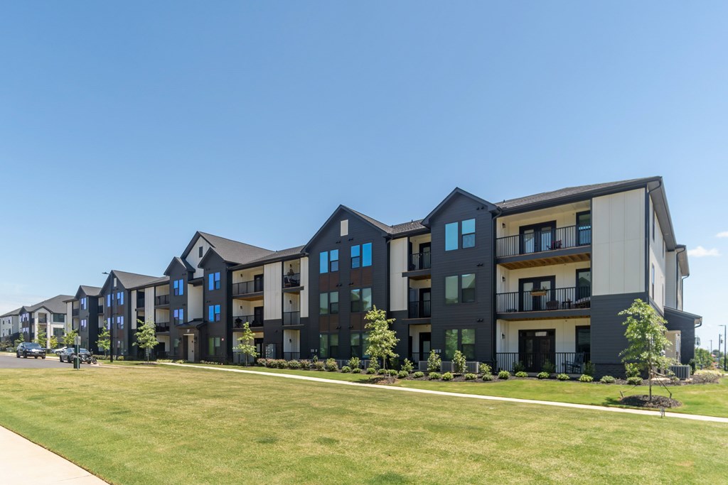 A row of modern townhouses with green lawns in front at Evolve Lake Norman apartments in Mooresville, NC
