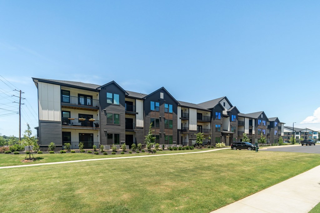 A row of modern townhouses with a car parked in front of the first one at Evolve Lake Norman apartments in Mooresville, NC