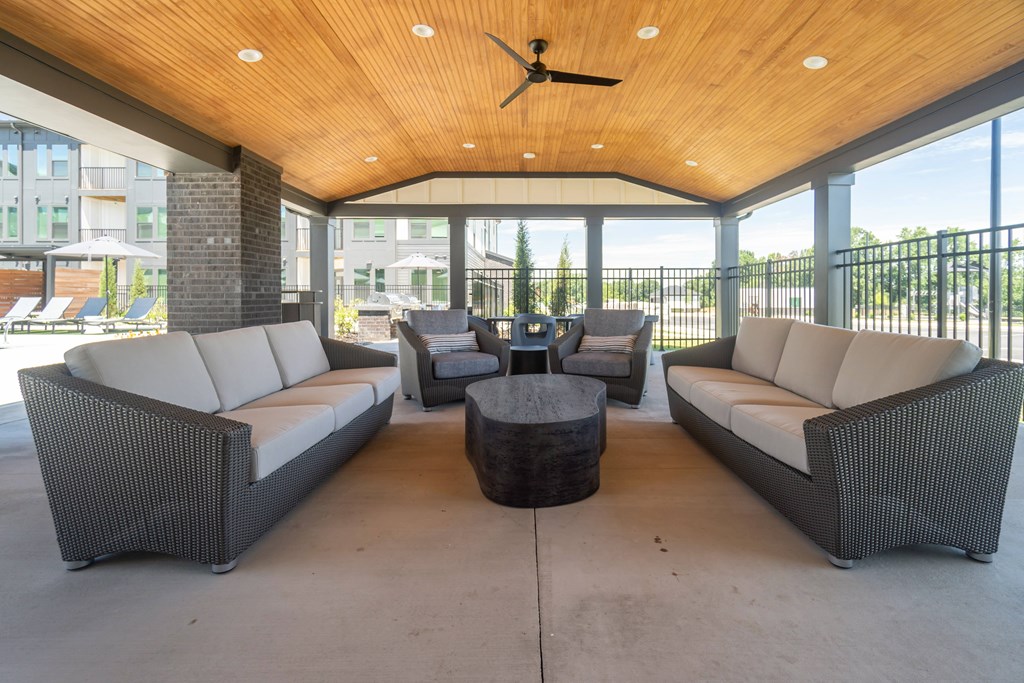 A patio with a ceiling fan and wicker furniture at Evolve Lake Norman apartments in Mooresville, NC