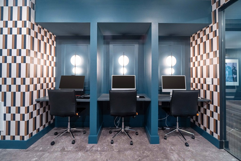 A room with a checkered wallpaper and a row of chairs and desks at Evolve Lake Norman apartments in Mooresville, NC