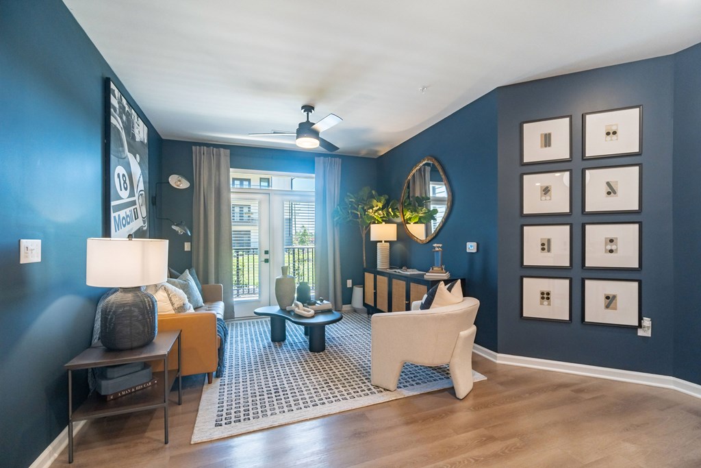 A living room with a white sofa and a grey rug at Evolve Lake Norman apartments in Mooresville, NC