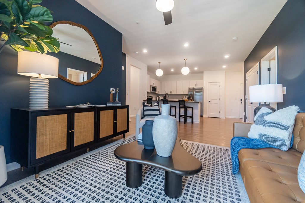 A living room with a brown leather couch and a coffee table at Evolve Lake Norman apartments in Mooresville, NC