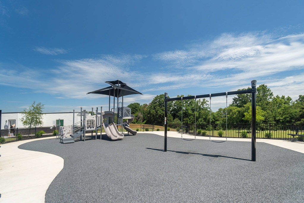 A playground with a slide, swings, and a climbing structure at Evolve Lake Norman apartments in Mooresville, NC