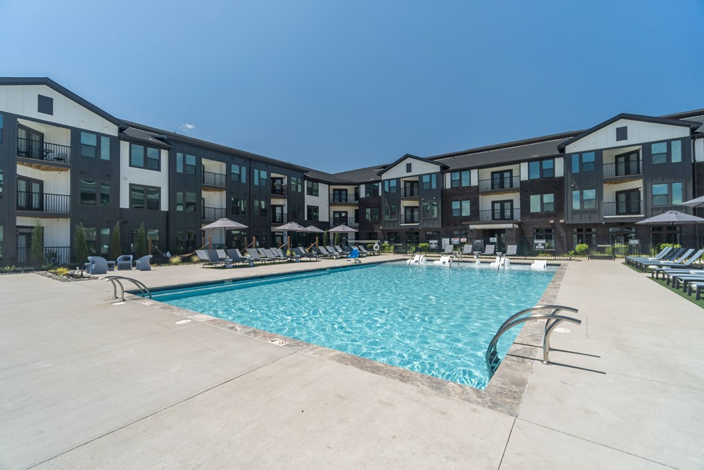 A large swimming pool in front of apartment buildings at Evolve Lake Norman apartments in Mooresville, NC