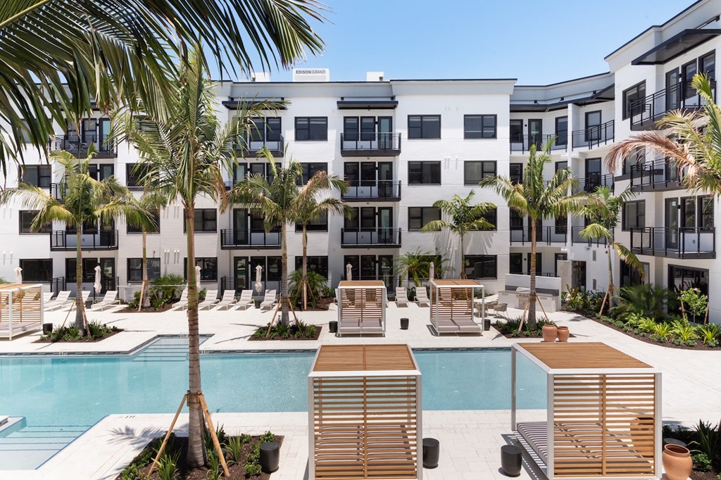 an apartment building with a pool and palm trees