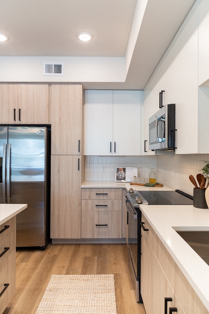a kitchen with white cabinets and a stainless steel refrigerator